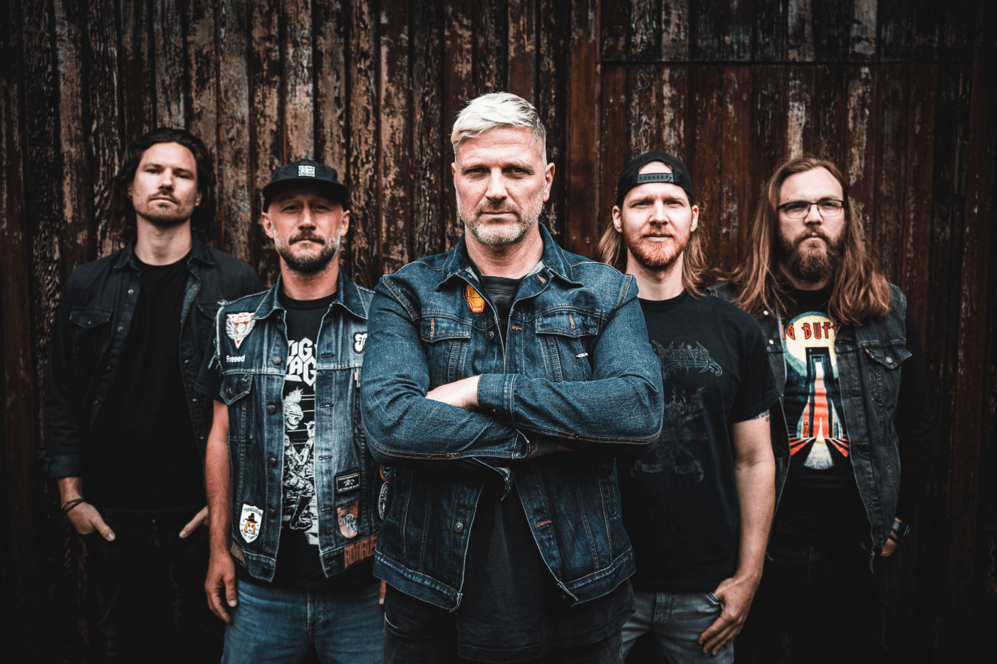 Bandfoto der Fastbeat Superchargers vor rustikaler Holzwand – ernsthafter Blick, klare Rock-Attitüde